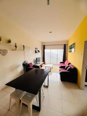 a living room with a table and a couch at Rayyan'Homestay PRIMA in Tanah Rata
