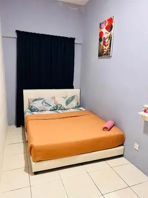 a bedroom with a bed with an orange blanket at Rayyan'Homestay PRIMA in Tanah Rata