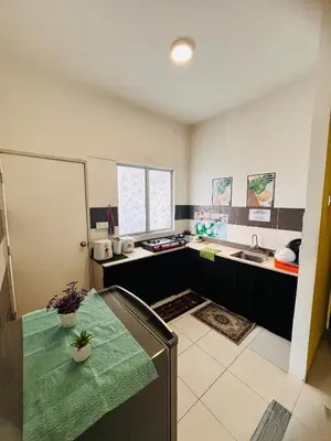 a kitchen with a table and a sink at Rayyan'Homestay PRIMA in Tanah Rata