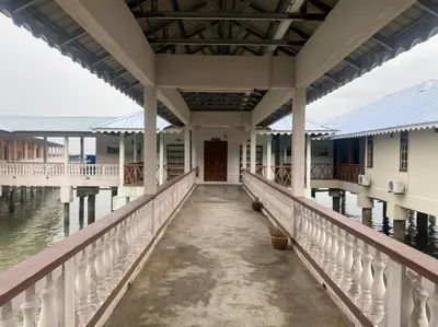 a walkway to a house on the water at Capital O 91118 Chalet Seri Idaman in Kampong Batu Maung