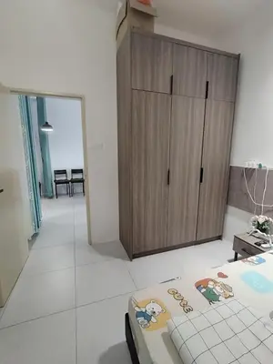a bedroom with a cabinet and a bed in it at Cosy Townhouse in Tasek Gelugor in Ara Rendang