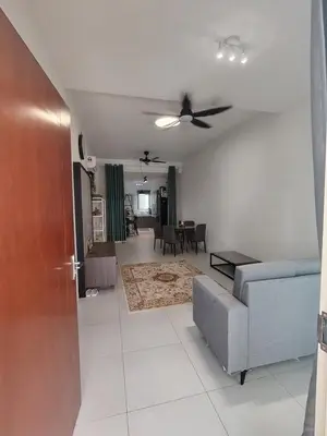 a living room with a ceiling fan and a couch at Cosy Townhouse in Tasek Gelugor in Ara Rendang