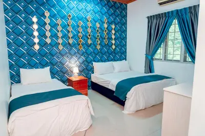 two beds in a room with a blue wall at Villa Sapphire by Blue Robin - Private Taiping Villa 20pax River & Waterfall in Taiping