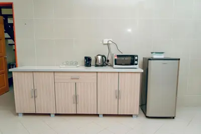 a kitchen with a counter with a microwave and a refrigerator at Villa Sapphire by Blue Robin - Private Taiping Villa 20pax River & Waterfall in Taiping