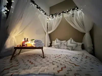 a bedroom with a canopy bed with a table with candles at The Little Bali Romance 2pax#Private Bathroom#2min KekLokSi in Ayer Itam