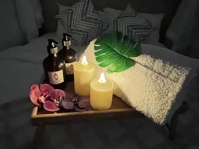 a tray with two candles and bottles on a bed at The Little Bali Romance 2pax#Private Bathroom#2min KekLokSi in Ayer Itam