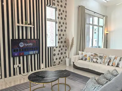 a living room with a couch and a table at Padang Serai Wangi Homestay in Padang Serai