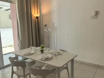 a dining room table with chairs and a white table and a window at Padang Serai Wangi Homestay in Padang Serai