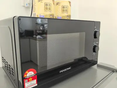 a microwave oven sitting on top of a table at Padang Serai Wangi Homestay in Padang Serai