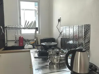 a kitchen with a stove top with pots and pans at Padang Serai Wangi Homestay in Padang Serai
