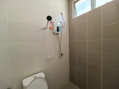 a bathroom with a toilet and a blow dryer on the wall at Padang Serai Wangi Homestay in Padang Serai