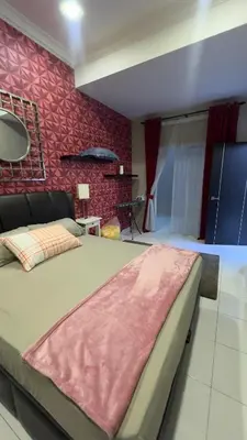 a bedroom with a large bed and a red wall at Md homestay in Kampong Kubang Menderong