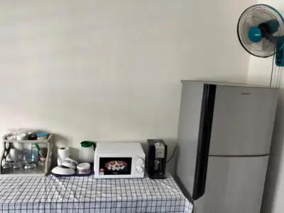 a kitchen with a microwave and a refrigerator at Homestay Panda Seri Iskandar Location nearby Uitm Utp KPM in Seri Iskandar