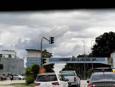 a traffic light with cars on a city street at Homestay Panda Seri Iskandar Location nearby Uitm Utp KPM in Seri Iskandar