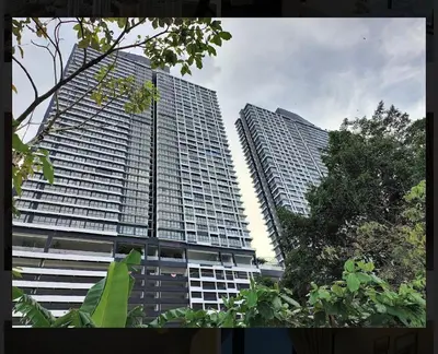 two tall skyscrapers with trees in front of them at Bright & airy 3BR homestay comfort penang Netflix in George Town