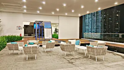 a lobby with chairs and tables in a building at Bright & airy 3BR homestay comfort penang Netflix in George Town