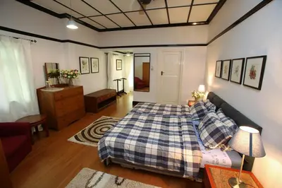 a bedroom with a bed and a couch at Bukit Lowick Bungalow in Tanah Rata