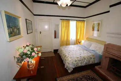 a bedroom with a bed and a vase of flowers on a table at Bukit Lowick Bungalow in Tanah Rata
