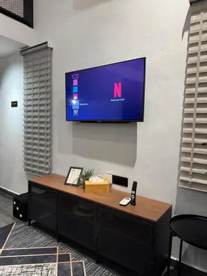 a tv hanging on a wall with a desk at Industrial Loft Tinyhouse Homestay - 2 Queen Bed, Free Netflix, Prime & Wi-Fi Near Bukit Mertajam in Kubang Semang