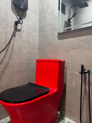 a red toilet with a red seat in a bathroom at Industrial Loft Tinyhouse Homestay - 2 Queen Bed, Free Netflix, Prime & Wi-Fi Near Bukit Mertajam in Kubang Semang