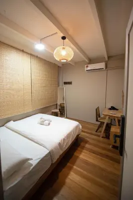 a bedroom with a bed and a table in it at DeLuma - Lebuh Melayu 4 Bedroom in George Town