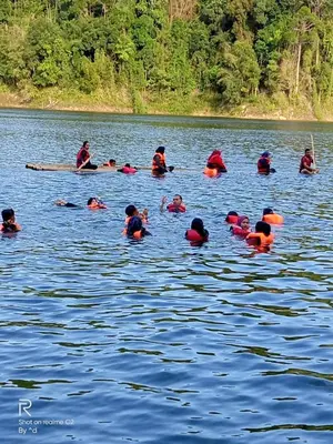 a group of people swimming in a body of water at House boat in Gerik