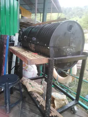 a grill sitting on top of a wooden table at House boat in Gerik