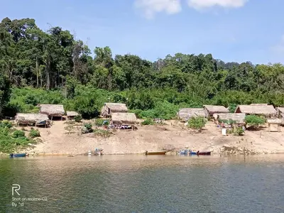 a group of huts on the shore of a river at House boat in Gerik