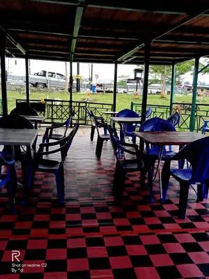 a checkered floor with tables and chairs in a restaurant at House boat in Gerik