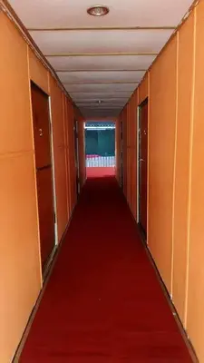 a long corridor with a red carpet in an empty room at House boat in Gerik