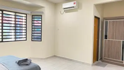 a bedroom with a bed and a air conditioner on the wall at Assyifa Homestay Kulim in Kulim