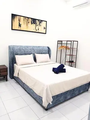 a bedroom with a bed with a blue pillow on it at Homestay Bunga Raya Wifi Netflix in Sitiawan