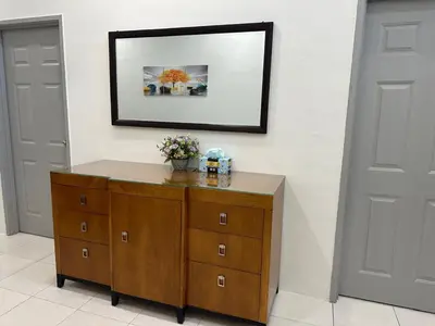 a wooden dresser in a room with a picture on the wall at Homestay Bunga Raya Wifi Netflix in Sitiawan