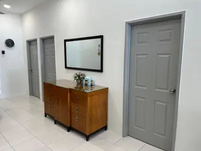 a room with a door and a dresser with a mirror at Homestay Bunga Raya Wifi Netflix in Sitiawan
