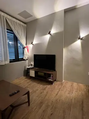 a living room with a flat screen tv and a table at Penang Georgetown studio home in George Town