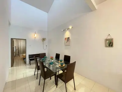 a dining room with a glass table and chairs at Jovial Single Storey Cozy Haus 9Pax in Lunas