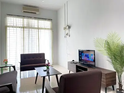 a living room with a tv and a couch and a table at Jovial Single Storey Cozy Haus 9Pax in Lunas