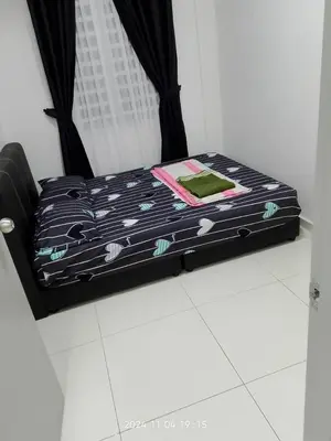 a bed with a black and white comforter on the floor at Prima Resident Meru Ipoh in Ipoh