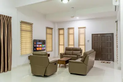 a living room with two chairs and a tv at Hi-Tea HomeStay in Sungai Petani