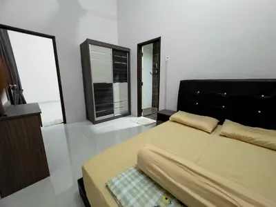 a bedroom with a bed and two large windows at Hi-Tea HomeStay in Sungai Petani