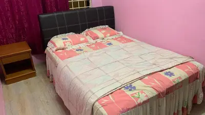 a bed in a bedroom with a pink wall at Homestay Bintang Maya in Sungai Petani