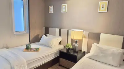 a hotel room with two beds and a lamp at Penang Oceanview Loft in George Town