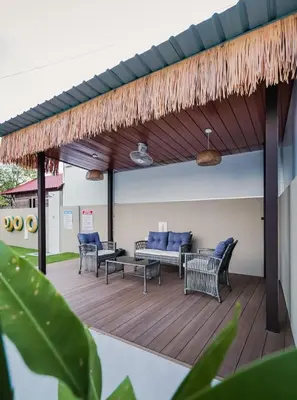 a patio with a couch and chairs on a wooden deck at Dyra Homestay in Lumut in Lumut