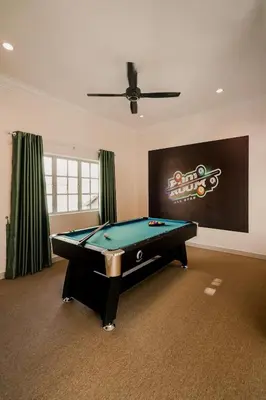 a pool table in a living room with a ceiling fan at Dyra Homestay in Lumut in Lumut
