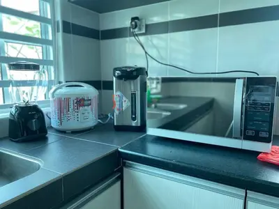 a kitchen with a counter top with a microwave at Dyra Homestay in Lumut in Lumut