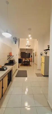 a large kitchen with white tile floors and a table at Ipoh Meru Landed Homestay TropiCasa 28 in Ipoh
