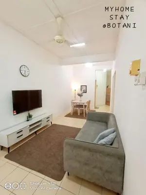 a living room with a couch and a tv at MyHomestay Botani in Ipoh