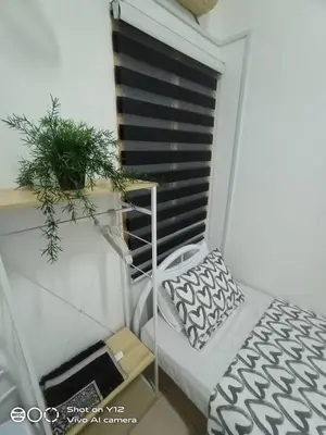 a small balcony with a bed and a potted plant at MyHomestay Botani in Ipoh