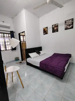 a bedroom with a bed and a table in it at Suria Permai19 Homestay in Taiping