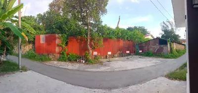 an empty street with a red fence and trees at Jemput Rezeki Homestay in Bayan Lepas